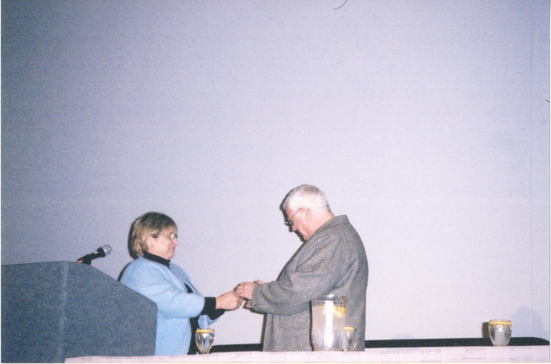Photograph of Sally Oddi Giving the Jo Osborne Award to Tomie dePaola