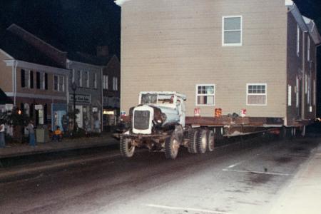 Color photo of the Old Rectory being moved on a flatbed truck