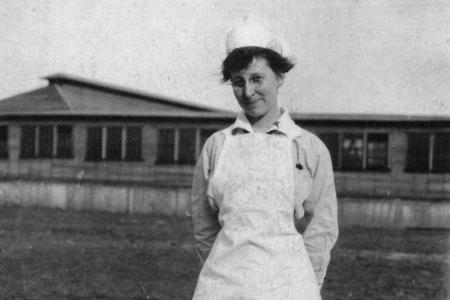 Harriet Elizabeth Putman Standing in Field in Front of Building